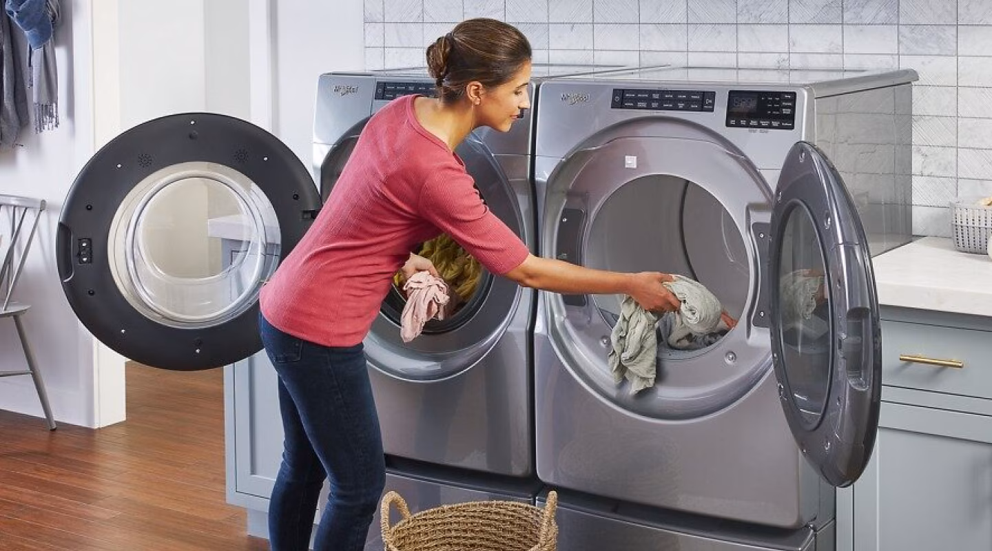 A modern white clothes dryer with an open door